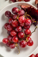 Pink grapes in a white plate, autumn harvest concept.