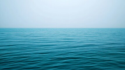 Obraz premium Tranquil expanse of still water, showcasing the deep blue hues of the ocean's surface, with a serene sky.