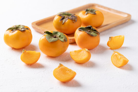 Sliced fresh ripe persimmon on white background, Autumn sweet fruit