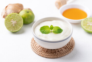 Yogurt, lime, honey and ginger on white background