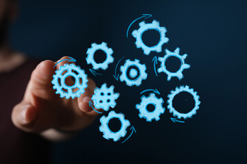 Image of hand interacting with blue gears symbolizing teamwork, workflow, and strategic planning. Ideal for business concepts.