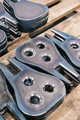 Stack of machined steel parts with circular drilled holes, precision-cut metal components for industrial engineering and manufacturing