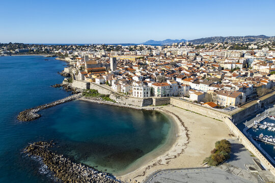 Aerial view of the historic Ch&Atilde;&cent;teau Grimaldi overlooking the calm, turquoise waters, with sandy beaches contrasting against the old stone walls, Antibes, Provence-Alpes-C&Atilde;&acute;te d'Azur, France.