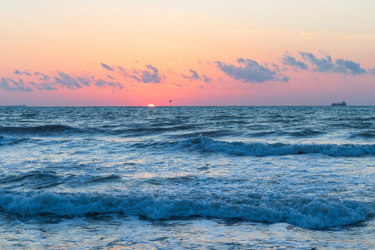 Sunrise at the beach  on a windy summer's morning. The Sun is above the horizon. The Sun is rising from the sea. - Powered by Adobe
