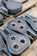 Stack of precision-cut metal parts with holes, industrial steel components manufactured for heavy machinery assembly