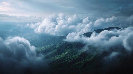 Dramatic clouds drift over lush green mountain peaks creating an ethereal atmospheric landscape