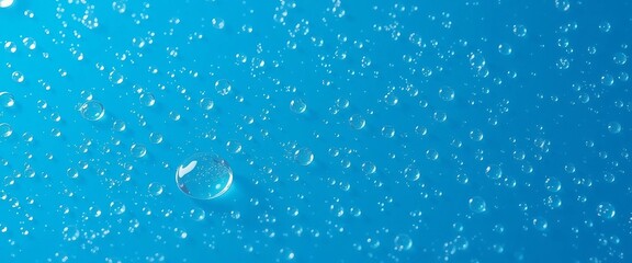Clear water drops floating on bright blue background with fresh atmosphere.