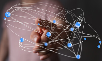 Abstract image depicting a hand interacting with a complex network of interconnected nodes, symbolizing global connectivity and data flow.