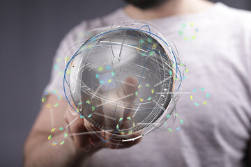 A man interacts with a futuristic holographic globe, showcasing global network connectivity and...