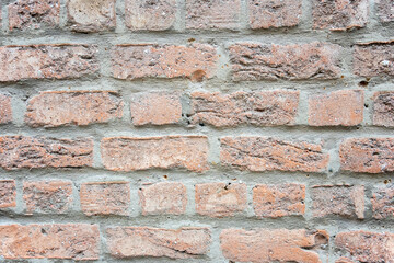 Stone wall with much brown bricks of the modern building.