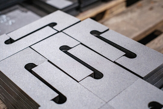 Stacked laser cut metal sheets in factory, precision steel panels for industrial manufacturing and engineering production