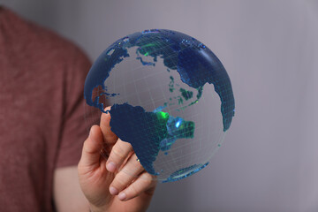 Hand holding a digital globe, symbolizing global connection, network, technology, and future.