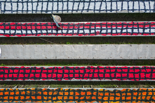 Aerial view of vibrant, patterned cloths laid out to dry under the Indonesian sun, a spectacle of color and texture in Mojolaban, Sukoharjo, Central Java, Indonesia.