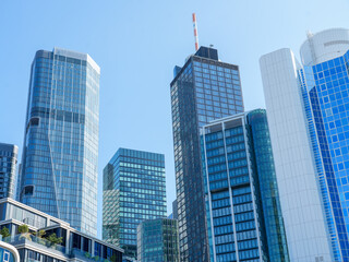 Modern glass skyscrapers in Frankfurt's financial district under a clear blue sky