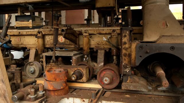 Old industrial machine equipment in lumber mill workshop on factory. Wood manufacturing and carpentry on plant, timber industry. Many broken metal details parts. Woodworking production manufacturing.