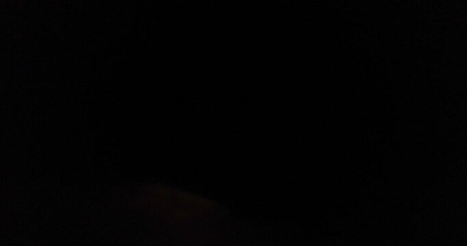 Waning crescent red moon rises and hides in night clouds, time lapse