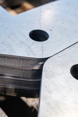 Close-up of stacked steel plates with precision drilled holes, industrial laser cutting and metal...