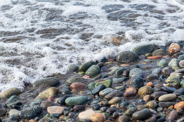 Close up shot of the pebbles of the beach. Background