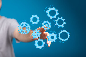 Abstract image of hand interacting with digital gears, symbolizing teamwork, process, technology, and innovation.