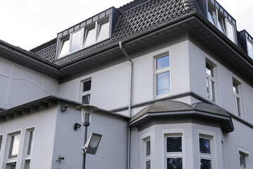 Stock photo of a modern grey house with dormer windows, showcasing architectural details and exterior design.