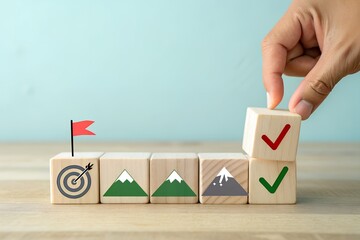 Hand placing final block to complete goal achievement with checkmarks