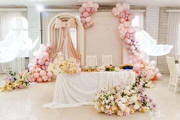 Festive setup with pink balloons and floral arrangements