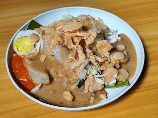 Gado Gado, traditional Indonesian vegetable salad with peanut sauce, chili sauce, lontong, tofu, cucumber, potatoes, and egg.