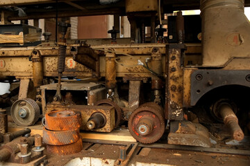 Old industrial machine equipment in lumber mill workshop on factory. Wood manufacturing and carpentry on plant, timber industry. Many broken metal details parts. Woodworking production manufacturing.