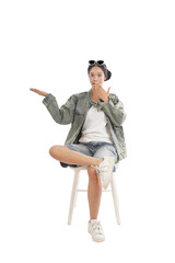 Contemplative Ponder: A young woman, poised with sunglasses perched atop her head, sits and gestures, lost in contemplation. Reflecting on the world around her.