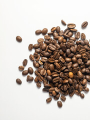 Roasted coffee beans scattered on white background