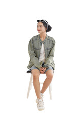 Youthful Contemplation: A young female with casual attire gazes thoughtfully, seated gracefully on a minimalist stool, suggesting quiet reflection and introspection.
