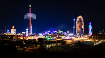 Panorama of the Oktoberfest in Munich at night - world-famous folk festival with colorful lighting,...