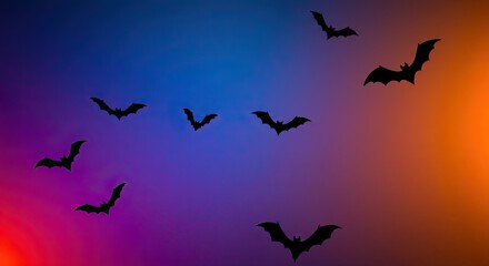 Fototapeta premium Spooky bats silhouette flying across a vibrant Halloween night sky