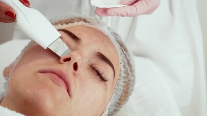 Beautician using ultrasound exfoliation device during skincare session in aesthetic center. Expert applying advanced tool for gentle cleansing and revitalization. Client receiving professional care