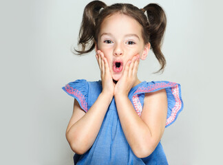 The child is a beautiful girl with wide eyes, look away in surprise. Baby in a knitted sweatshirt ....