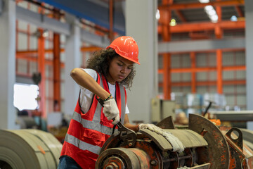 Female workers in a steel factory are repairing machinery.