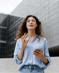 Deaf person communicating on smartphone using sign language app, modern urban background
