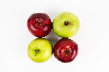 A top down shot of four red and green apples arranged in a square.