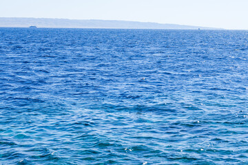 The ocean is calm and blue, with no visible waves