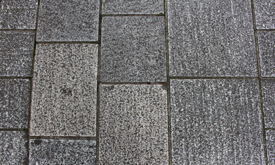 Texture of gray and beige square paving tile. Pattern of sidewalk tiles in the street. Concrete pavers close up background.	