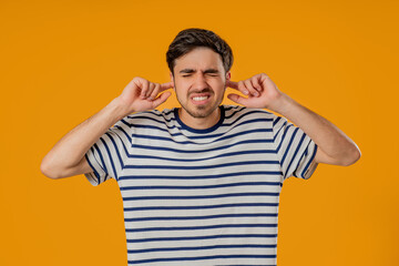Annoyed Man With Shut Ears On Yellow. Guy Block Annoying Sounds, Loud Music