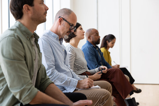 Man taking notes during a presentation
