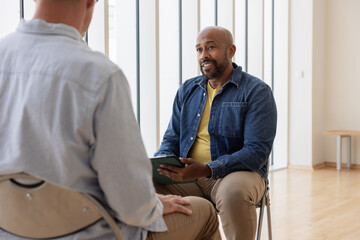 Unrecognisable male client listens as counsellor gives advice