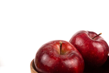 Close up view captures two fresh apples resting inside a rustic container studio shot.