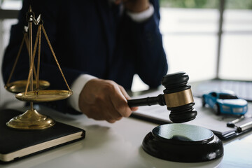 Lawyer in suit working at desk with gavel, justice scale, and legal documents, symbolizing law, judgment, and legal decision-making.