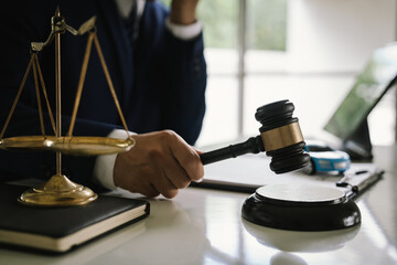 A judge holding a gavel hitting a toy car in a contract document represents automotive law, insurance disputes, car ownership, and legal decisions.