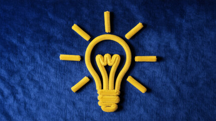 Illuminating yellow lightbulb symbol crafted from textured material radiates brilliant ideas and innovation on a deep blue textured surface, symbolizing inspiration.