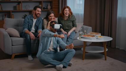 Four diversity ethnic friends at home party African american Latina man playing VR battle buddies men women saupporting applauding motivating virtual reality technology AR headset metaverse game using