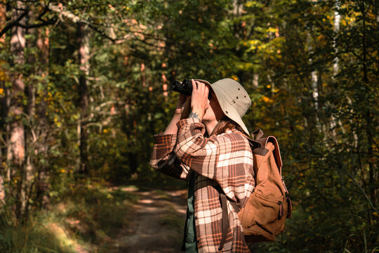 A young man explores the forest and its animals and birds through binoculars