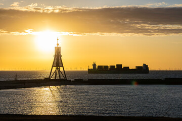 Germany. Cuxhaven. Kugelbake (historical day beacon) located at the mouth of the Elbe River and passing container ship